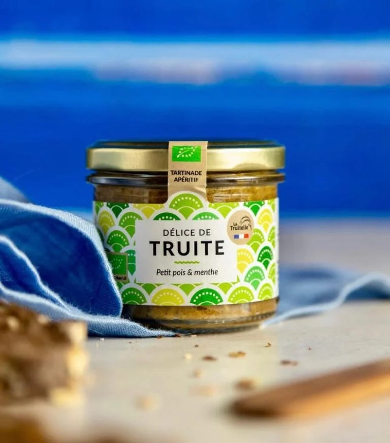 La Truitelle trout spread with peas and mint on a table, against a blue background